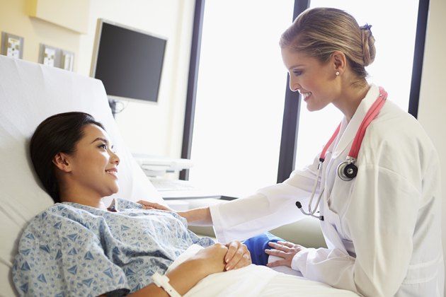 Doctor Talking To Female Patient On Ward
