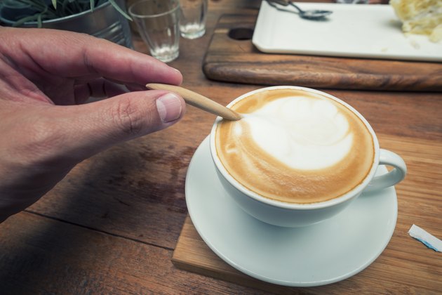 Close up hand mixing with a spoon of coffee.