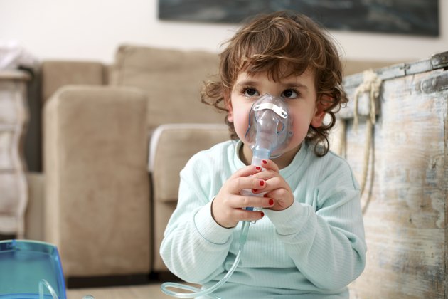 Portrait of a little girl with inhaling mask