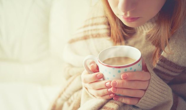 warm cup of hot coffee warming in the hands of a girl