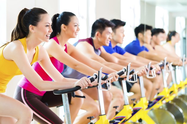 Asian people spinning bike training at fitness gym
