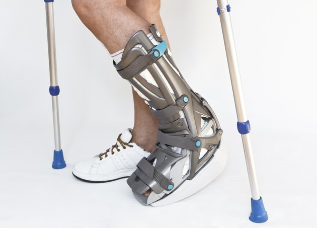 Man with a broken leg walking on crutches