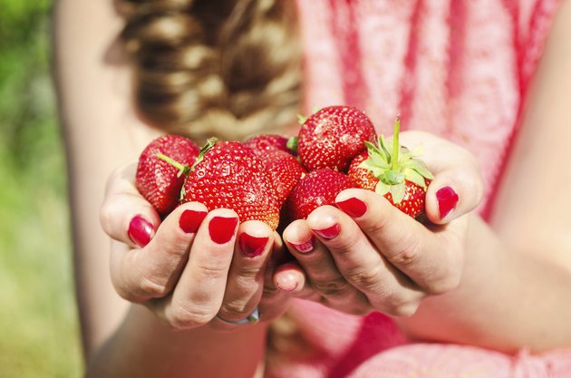 Hands of woman holding fresh strawberries