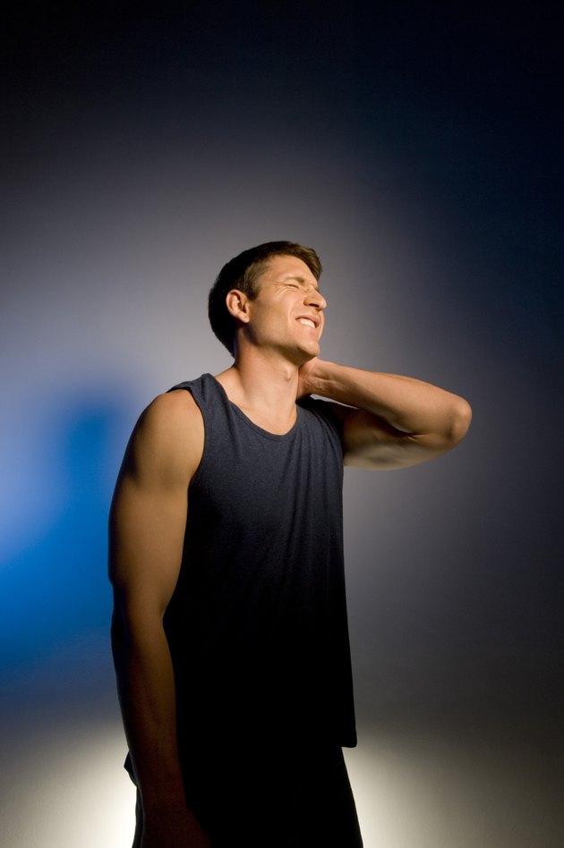 Man rubbing sore neck
