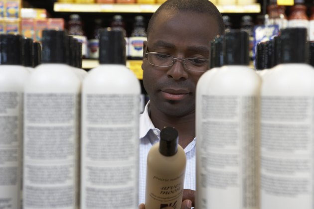 Man reading shampoo label in store, close-up
