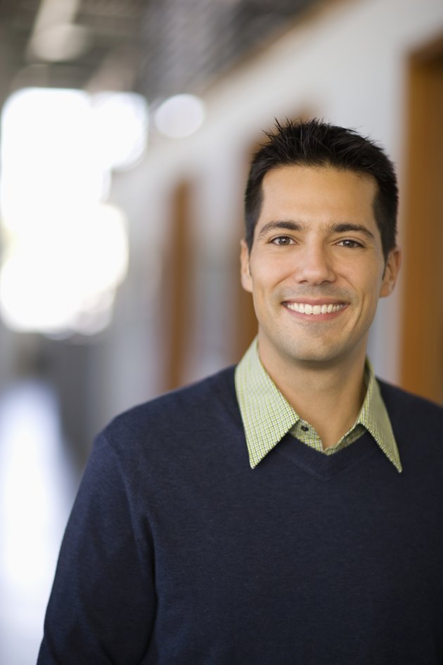 Businessman standing in hallway of office, portrait