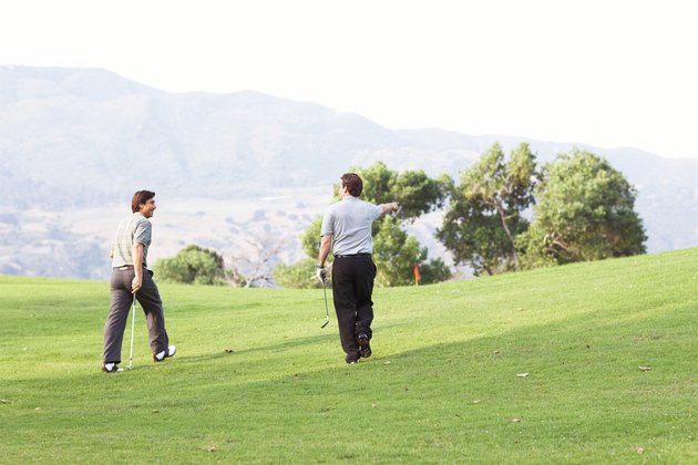Golfers walking on green