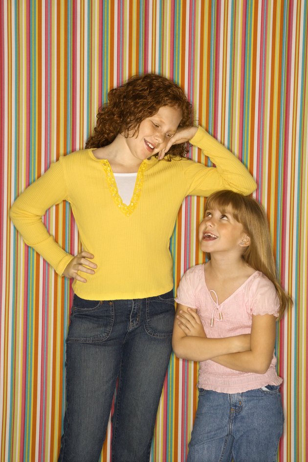 Girl leaning on smaller girl.