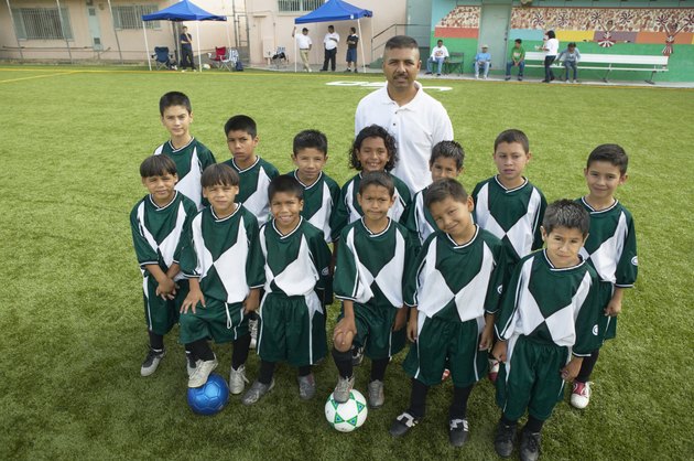 Portrait of boys (7-11) football team with coach