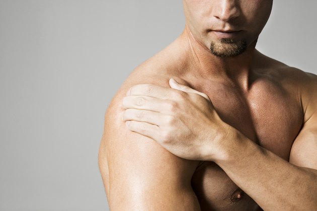 Man massaging shoulder, mid section