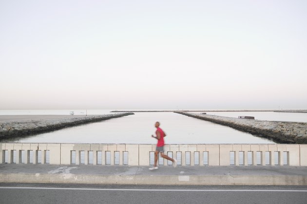 African American male runner on bridge