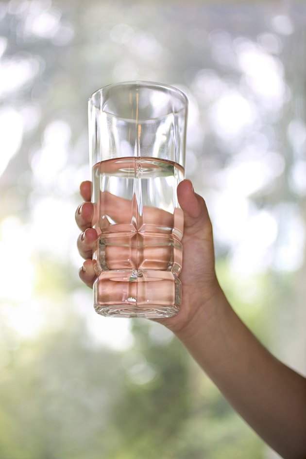 Hand holding glass of water