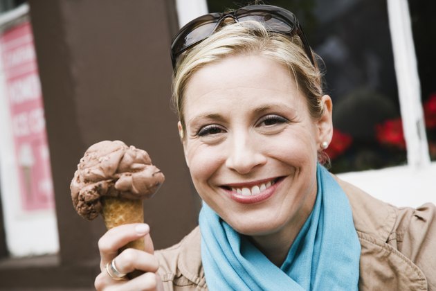 Woman holding an ice-cream cone and smiling