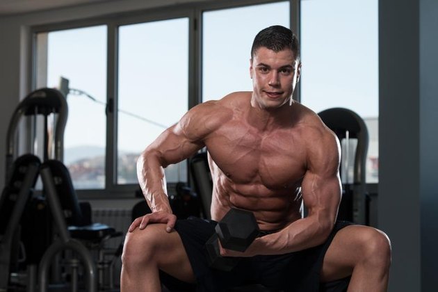 Young Physically Bodybuilder Working Out Biceps - Dumbbell Concentration Curls