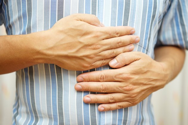 Stomach ache, man placing hands on the stomach, concept of .stomach ulcer
