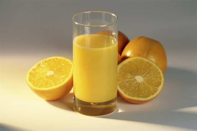 Glass of orange juice and oranges