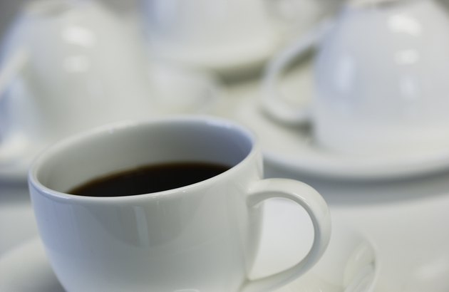Tilted close-up of a cup of coffee with other cups in the background