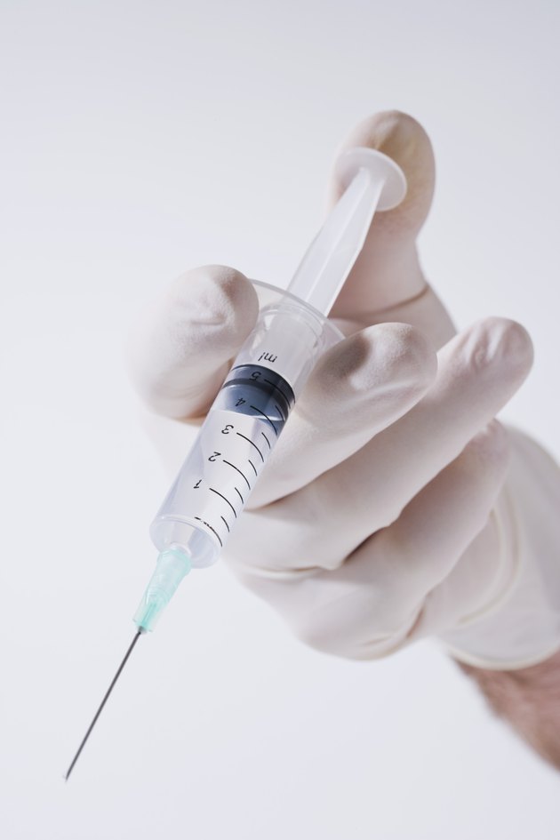 Person pushing hypodermic syringe
