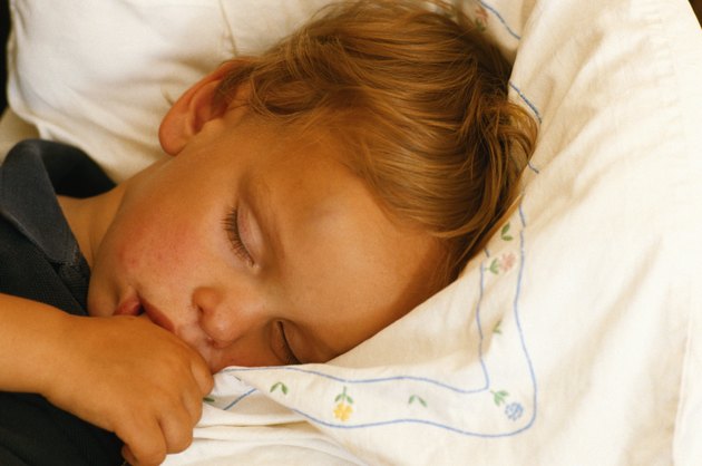 Boy (4-5) sleeping, thumb in mouth, close-up