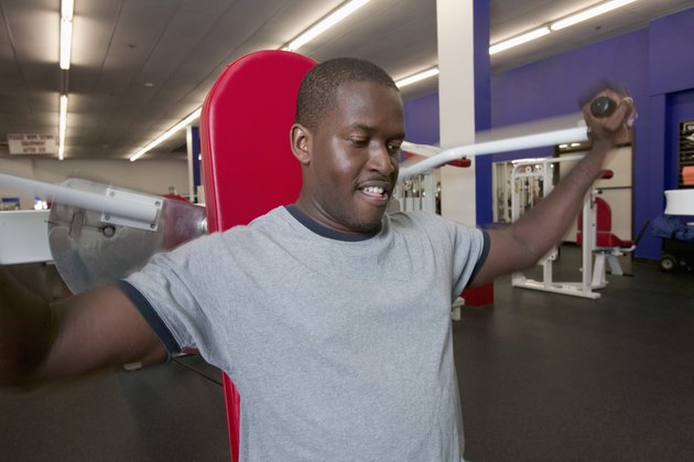 Man using shoulder machine in gym