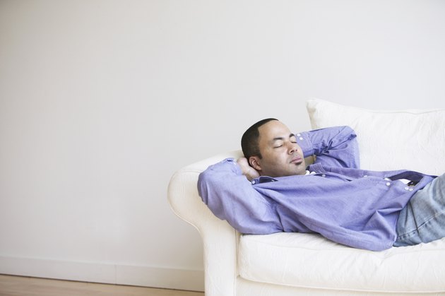 African man sleeping on sofa