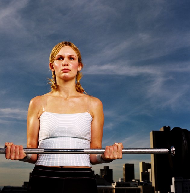 Portrait of a young woman carrying a barbell