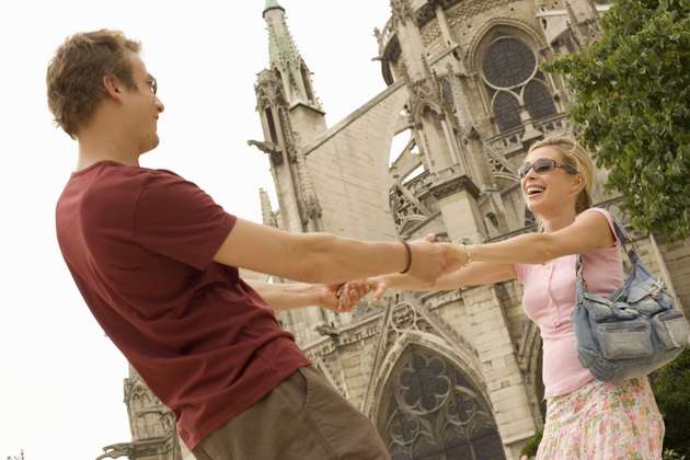 France, Paris, Notre-Dame, couple holding hands, smiling