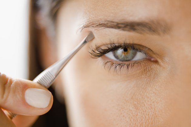 Woman plucking her eyebrows