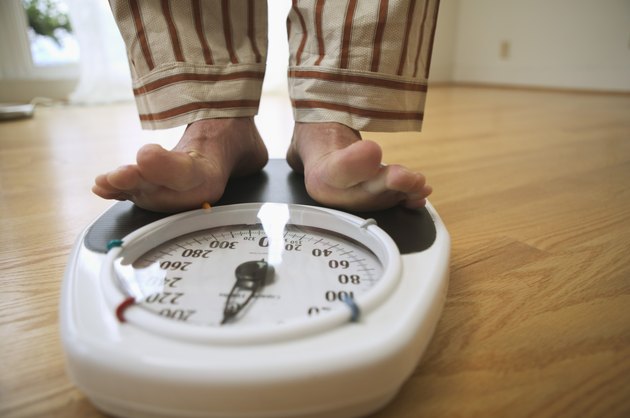 Man weighing himself on a bathroom scale