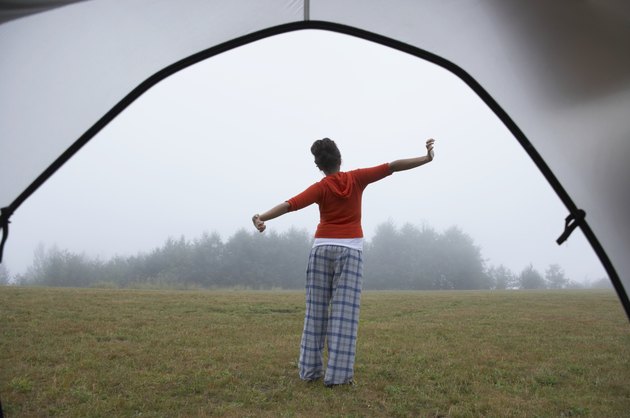 Indian woman in pajamas stretching at campsite