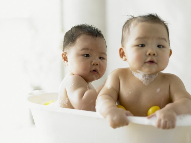 Twin baby boys playing in the bathtub