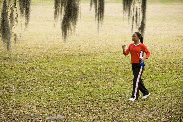 Young woman in sports clothing jogging on ground