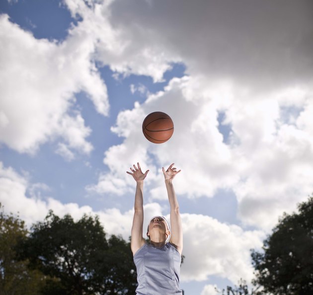 Woman playing basketball outdoors