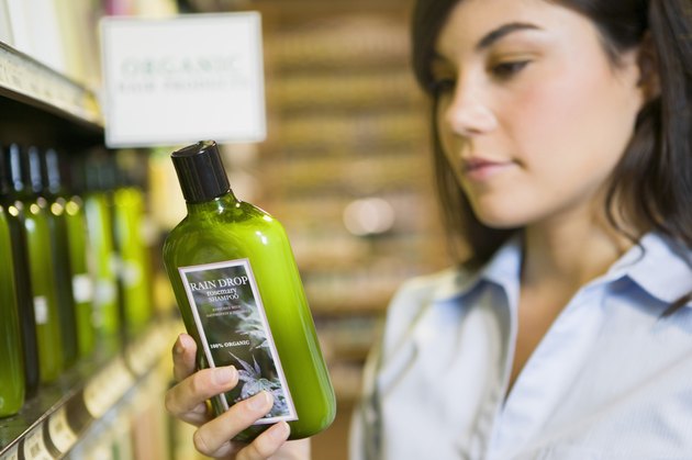 Woman reading label of organic shampoo