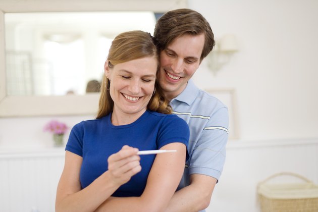 Happy man and woman with pregnancy test