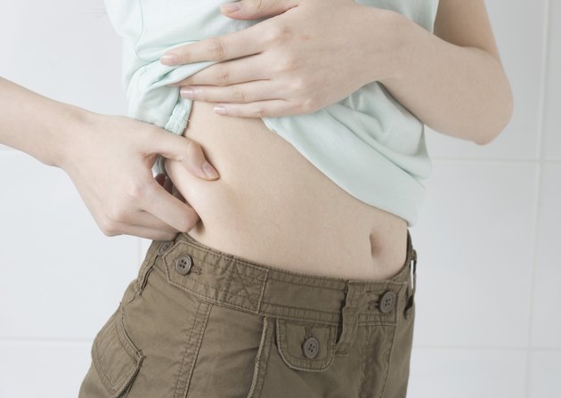 Woman squeezing fat at waist