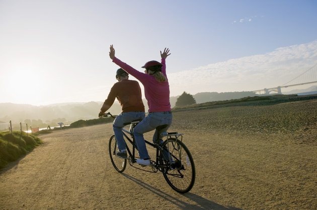 Woman and man riding tandem bicycle