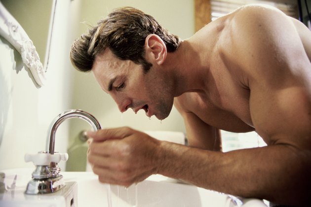 Side profile of a young man washing his face