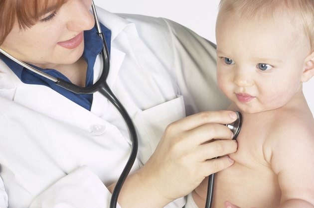Doctor holding and monitoring baby with stethoscope