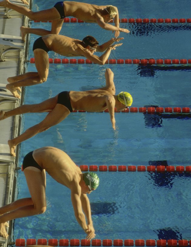 Swimmers diving into pool