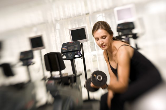 Woman lifting weights in gym