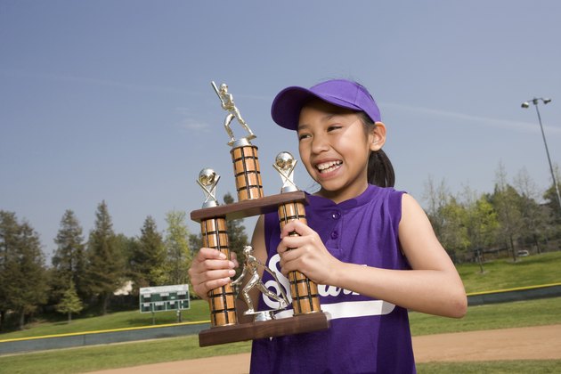 Little league player holding trophy