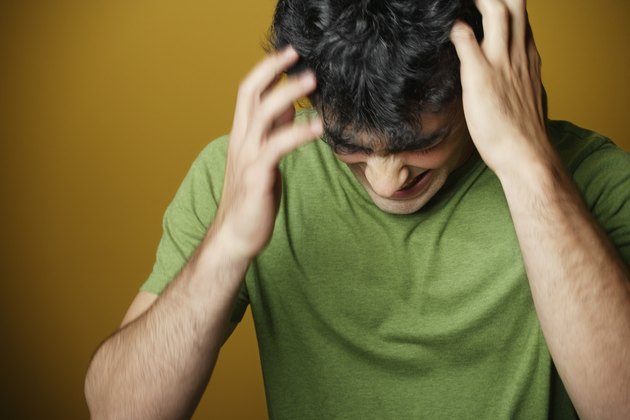 Young man holding head
