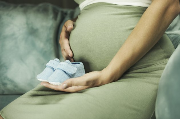 Cropped pregnant woman with blue booties