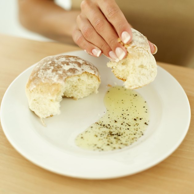 Close-up of a woman's hand holding a bap on a plate