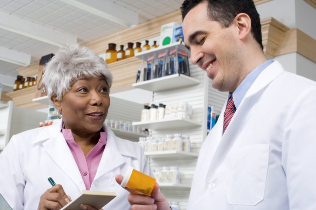Pharmacists talking and holding medication