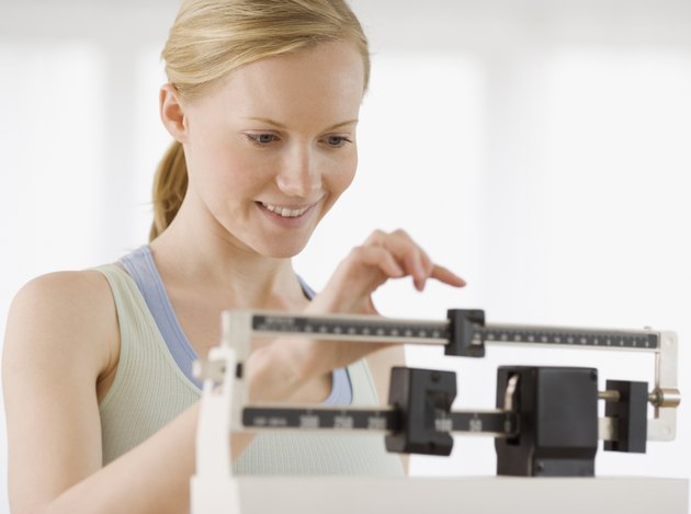 Woman weighing self on scale