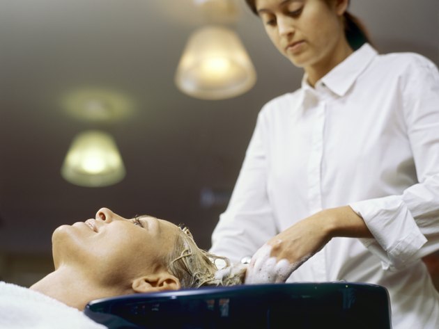 Low angle view of a hairdresser shampooing a young woman/s hair