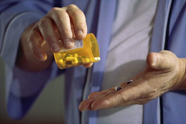 Close-up of a person holding a bottle of pills