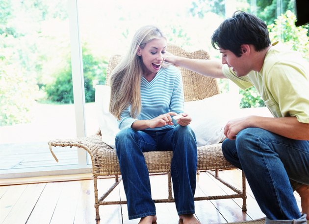 view of a teenage boy and girl sitting outdoors and talking